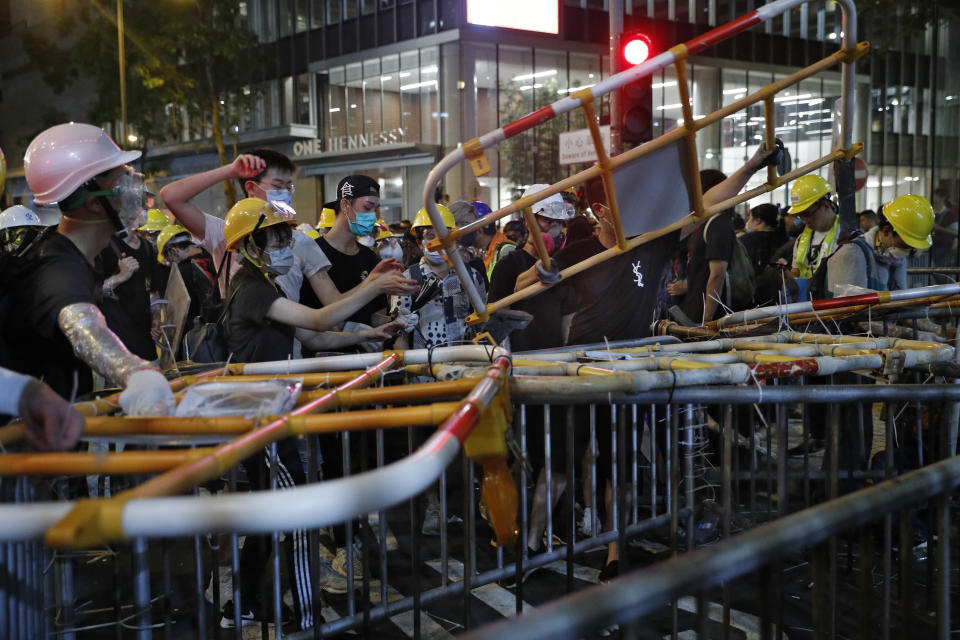 Protesters set up barriers to block the police headquarters in Hong Kong, Friday, June 21, 2019. More than 1,000 protesters blocked Hong Kong police headquarters into the evening Friday, while others took over major streets as the tumult over the city's future showed no signs of abating. (AP Photo/Vincent Yu)