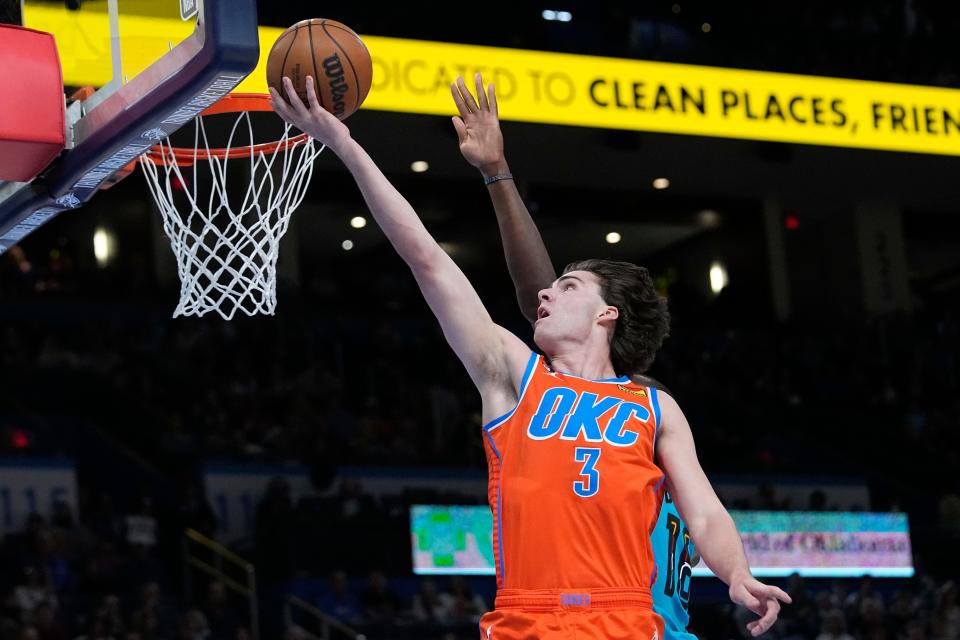 Oklahoma City Thunder guard Josh Giddey (3) shoots in front of Phoenix Suns center Bismack Biyombo, rear, in the first half of an NBA basketball game Sunday, March 19, 2023, in Oklahoma City. (AP Photo/Sue Ogrocki)