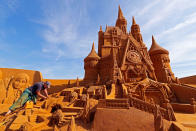 <p>Sand carver Susanne Paucker from Germany works on a sculpture during the Sand Sculpture Festival “Disney Sand Magic” in Ostend, Belgium June 22, 2017. (Yves Herman/Reuters) </p>