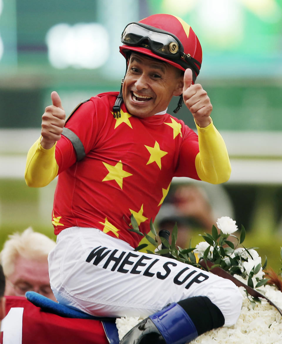 FILE - In this June 9, 2018, file photo, Jockey Mike Smith reacts after guiding Justify to win the Belmont Stakes horse race and the Triple Crown in Elmont, N.Y. The winning formula for a big race generally combines the talent of the horse, the prowess of the trainer and the skill of the jockey. Smith is now riding favored Improbable with familiar trainer Bob Baffert in Saturday's Preakness, bumping Irad Ortiz to new shooter Bourbon War.(AP Photo/Andres Kudacki, File)