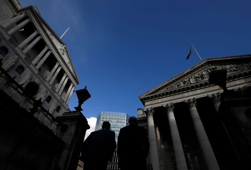 FILE PHOTO: Workers emerge from Bank underground station with the Bank of England and Royal Exchange building seen in the City of London financial district, London, Britain