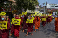 Buddhist monks lead an anti-coup protest march in Mandalay, Myanmar, Saturday, Feb. 27, 2021. Myanmar security forces cracked down on anti-coup protesters in the country's second-largest city Mandalay on Friday, injuring at least three people, two of whom were shot in the chest by rubber bullets and another who suffered a wound on his leg. "CRPH" in the placards stand for "Committee Representing Pyidaungsu Hluttaw." (AP Photo)