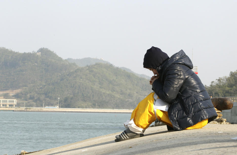 A relative of a passenger aboard the sunken ferry Sewol prays as she waita for her missing loved one at a port in Jindo, South Korea, Monday, April 21, 2014. Divers continued the grim work of recovering bodies from inside the sunken South Korean ferry Monday, securing a new entryway into the wreck, as a newly released transcript showed the ship was crippled by confusion and indecision well after it began listing. The transcript suggests that the chaos may have added to a death toll that could eventually exceed 300. (AP Photo/Ahn Young-joon)