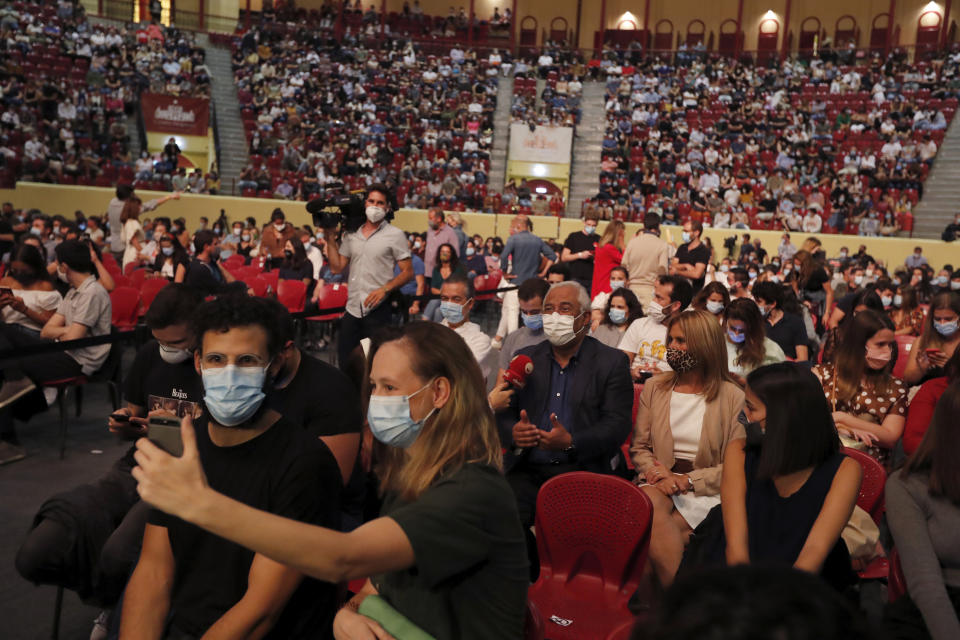 Portuguese Prime Minister Antonio Costa, center, and his wife Fernanda Tadeu wait for the start of a concert by Portuguese artists Bruno Nogueira and Manuela Azevedo at the Campo Pequeno bullring in Lisbon, Monday, June 1, 2020. Portugal is allowing concert halls to reopen from Monday as the government eases the coronavirus lockdown rules. (AP Photo/Armando Franca)