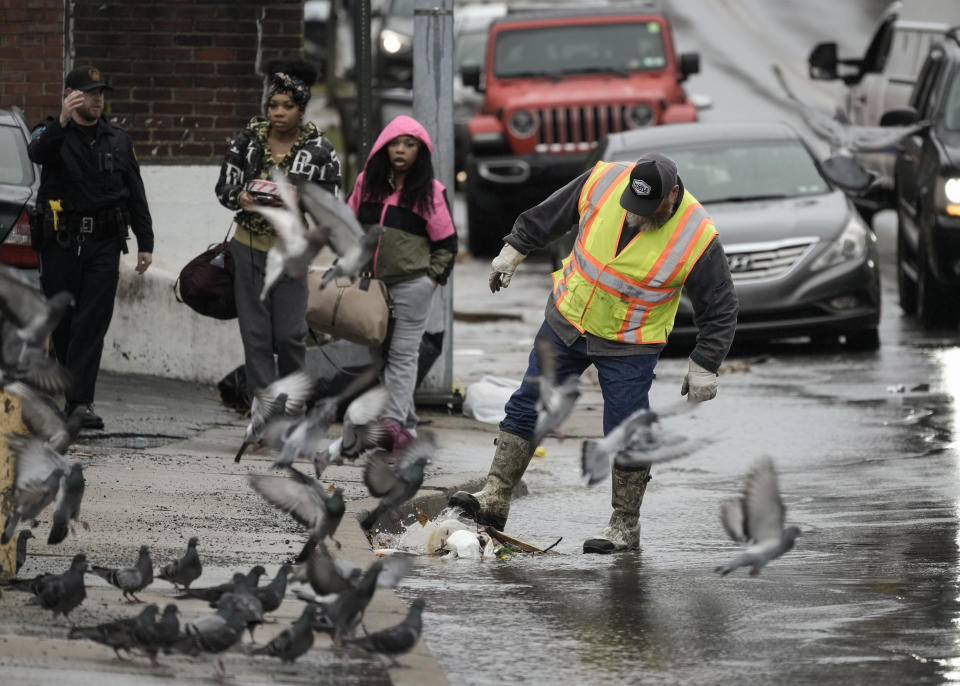 A worker clears debris from a storm drain in Collingdale, Pa., Monday, Dec. 18, 2023. A storm moving up the East Coast has brought heavy rain and high winds to the Northeast, threatening flooding, knocking out power to hundreds of thousands, and forcing flight cancelations and school closings. (AP Photo/Matt Rourke)