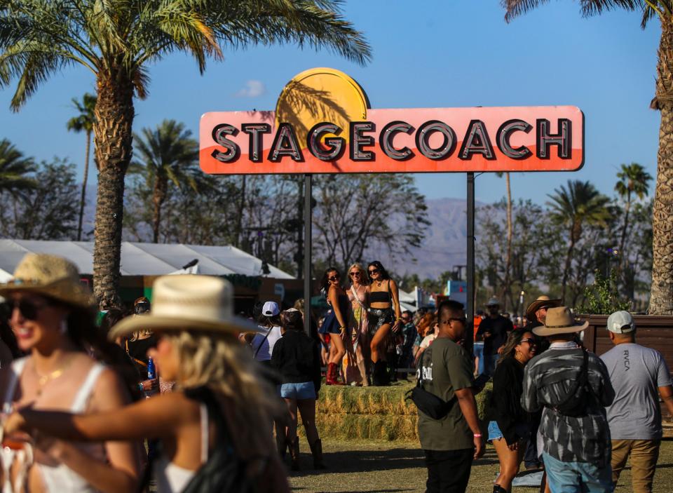 Festivalgoers pose for photos under the iconic Stagecoach sign during Stagecoach country music festival in Indio, Calif., Friday, April 26, 2024.