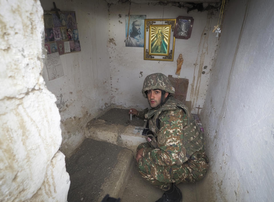 An Ethnic Armenian soldier lights a candle in a improvised chapel near a fighting position on the front line, during a military conflict against Azerbaijan's armed forces in the separatist region of Nagorno-Karabakh, Wednesday, Oct. 21, 2020. Armenia's prime minister has urged citizens to sign up as military volunteers to help defend the country amid the conflict with Azerbaijan over the disputed territory of Nagorno-Karabakh as intense fighting has raged for a fourth week with no sign of abating. (AP Photo)