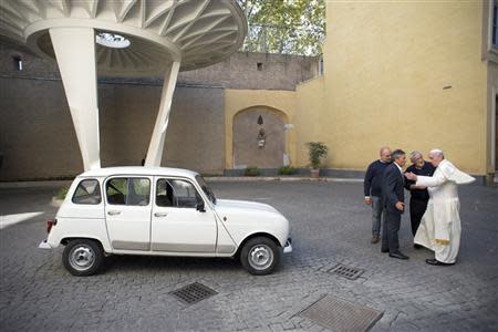 Pope Francis (R) is presented with a Renault 4 car during a private audience with Don Renzo Zocca at the Vatican in this picture taken September 7, 2013 and released by Osservatore Romano September 10, 2013. REUTERS/Osservatore Romano