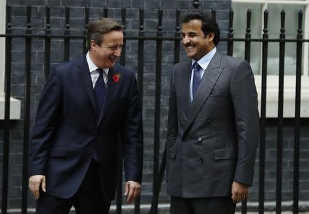 Britain's Prime Minister David Cameron (L) greets the Emir of Qatar, Sheikh Tamim bin Hamad Al Thani, as he arrives at Number 10 Downing Street in London October 29, 2014. REUTERS/Luke MacGregor
