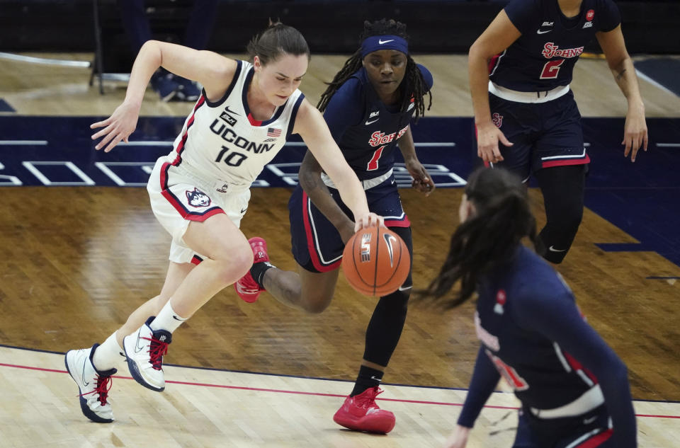 Connecticut guard Nika Muhl (10) brings the ball up as St. John's guard Unique Drake (1) defends during the second half of an NCAA college basketball game Wednesday, Feb. 3, 2021, in Storrs, Conn. (David Butler II/Pool Photo via AP)