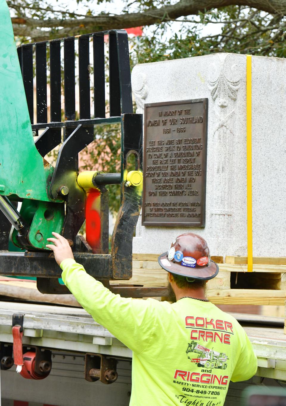 The pedestal and commemorative plaque that held the bronze statue of a women reading to two children is moved to the bed of a flatbed truck after being removed from the "Women of the Southland" monument on Dec. 27.