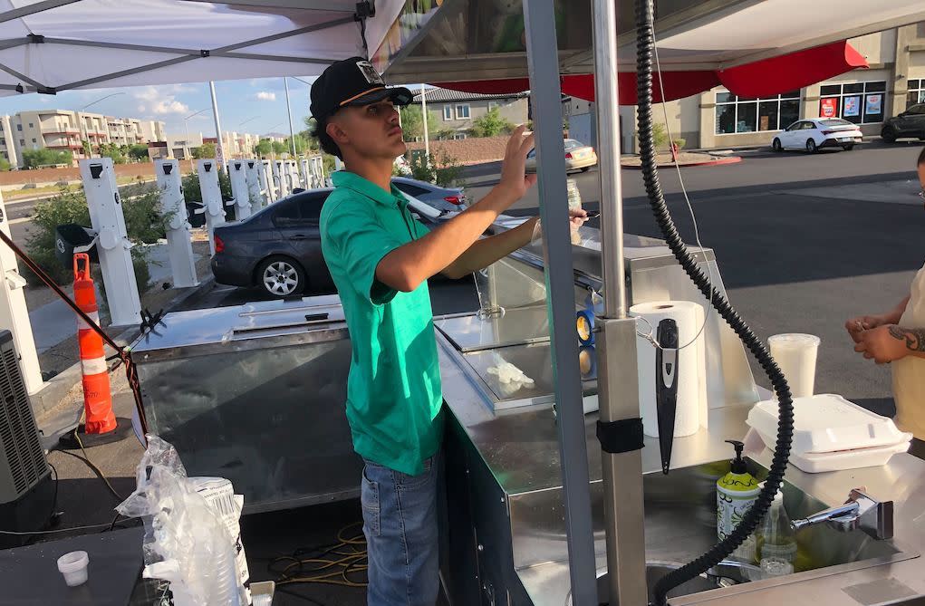 A man works at a food stand.