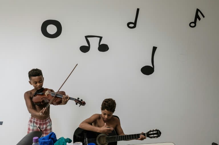 Boys play instruments in a free music class inside a station of the cable car system which is no longer running, over the Alemao favela in Rio de Janeiro, Brazil