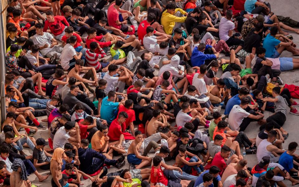 Unaccompanied minors who crossed into Spain are gathered outside a warehouse used as temporary shelter as they wait to be tested for COVID-19 at the Spanish enclave of Ceuta, near the border of Morocco and Spain, Wednesday, May 19, 2021 - AP/Bernat Armangue 