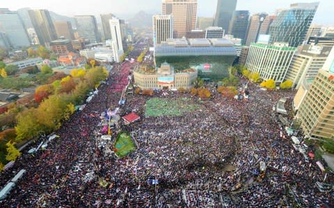 Up to a million protesters marched in central Seoul in 2016 to demand the resignation of then South Korean President Park Geun-hye  - Credit: AFP 