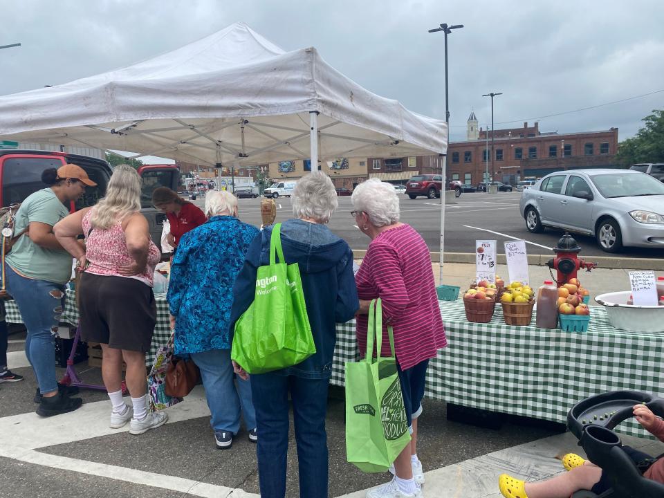 Shoppers look at fresh produce at the Canton Farmers Market in downtown Canton.
