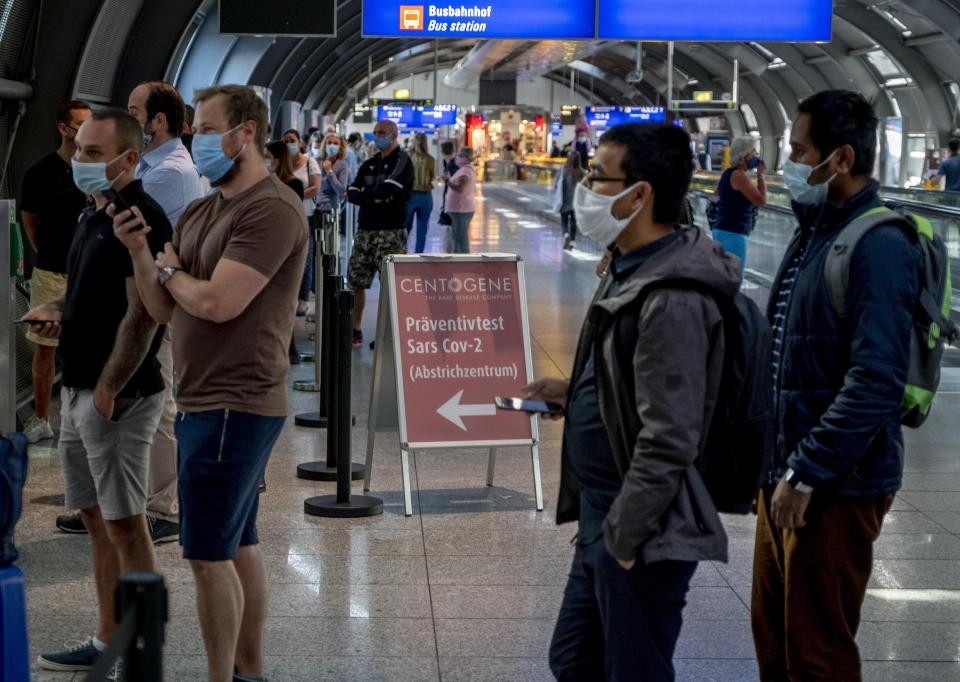 Dozens of passengers from various countries queue at the Centogene test center for a Covid-19 test at the airport in Frankfurt, Germany, Friday, July 24, 2020. (AP Photo/Michael Probst)