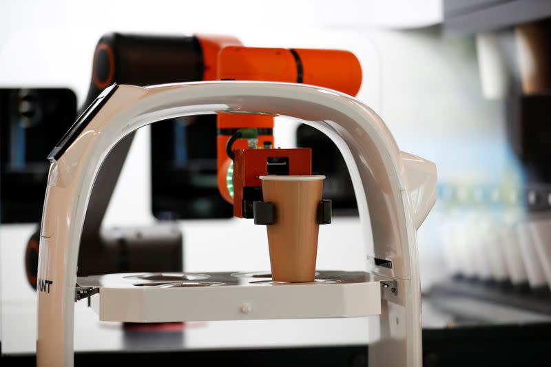 A robot that takes orders, makes coffee and brings the drinks straight to customers at their seats is seen at a cafe in Daejeon