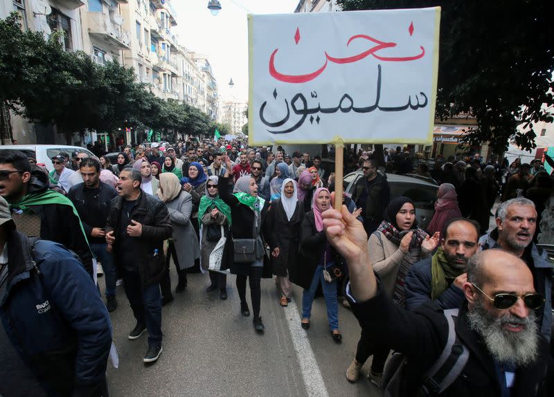 FILE PHOTO: A demonstrator holds a placard during an anti-government rally in Algiers,