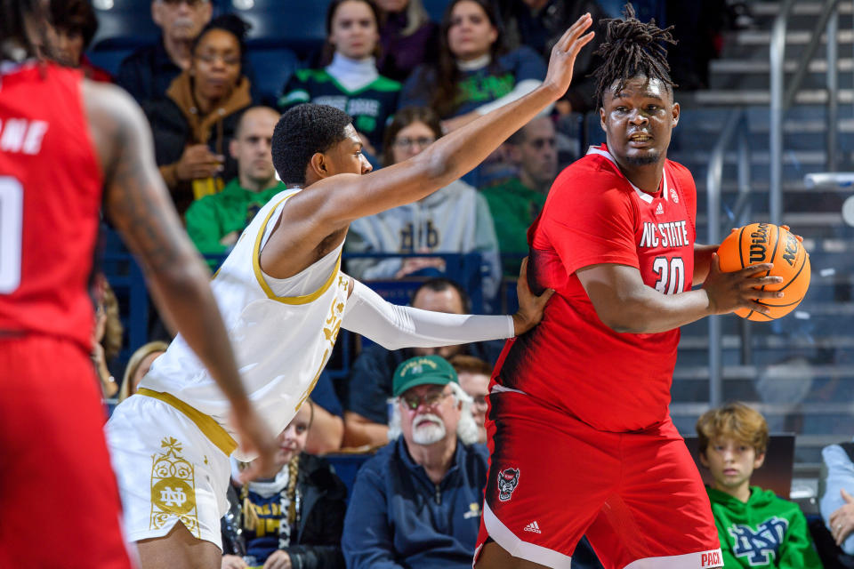 Jan 3, 2024; South Bend, Indiana, USA; North Carolina State Wolfpack forward DJ Burns, Jr. (30) looks to pass as Notre Dame Fighting Irish forward Kebba Njie (14) defends in the first half at the Purcell Pavilion. Mandatory Credit: Matt Cashore-USA TODAY Sports