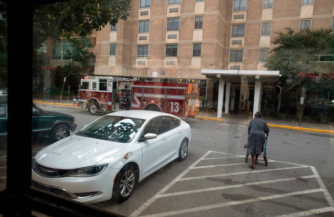 A resident of Glenwood Towers makes their way back inside as a Raleigh firefighters respond to one of several calls to the Raleigh Housing Authority’s housing facility for elderly and the disabled.