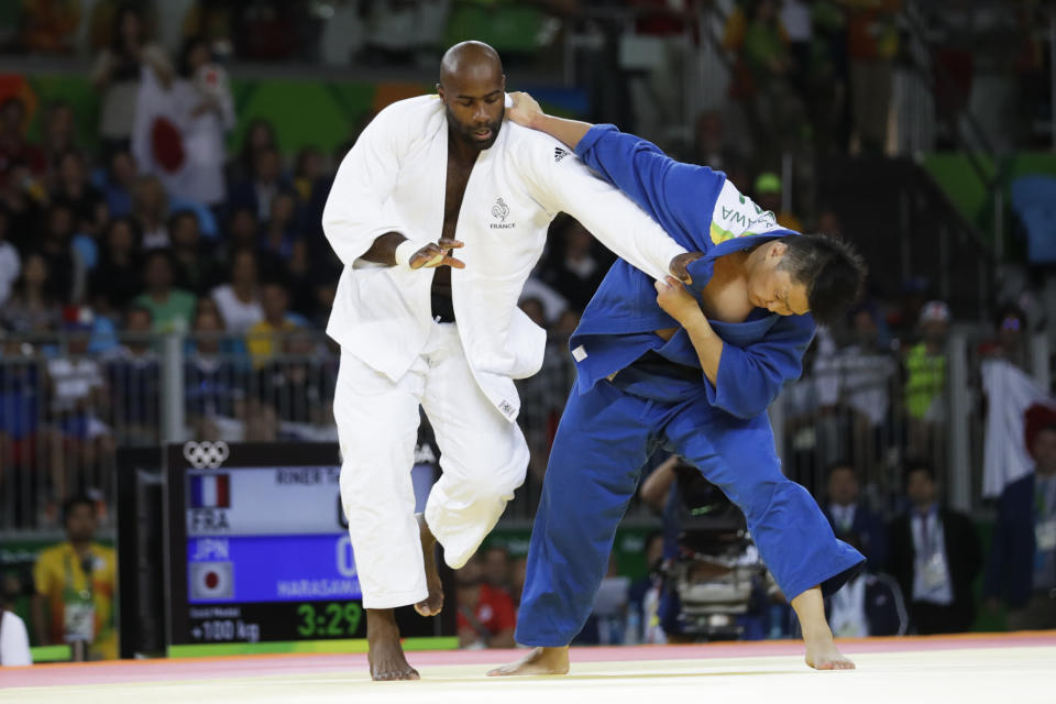 FILE - In this Friday, Aug. 12, 2016 file photo, France's Teddy Riner, left, competes against Japan's Hisayoshi Harasawa for the gold medal during the men's over 100-kg judo competition at the 2016 Summer Olympics in Rio de Janeiro, Brazil. Judo is coming home at the Tokyo Olympics, and the Japanese team is under a world of pressure. All of Japan’s stars will be tested, and not all are gold medal favorites. The rest of the world has dynamic champions, and the biggest is 6-foot-8 French heavyweight Teddy Riner, who won two Olympic gold medals and went undefeated in 154 consecutive matches for a full decade from 2010 to 2020 until he lost twice last year. (AP Photo/Markus Schreiber, File)