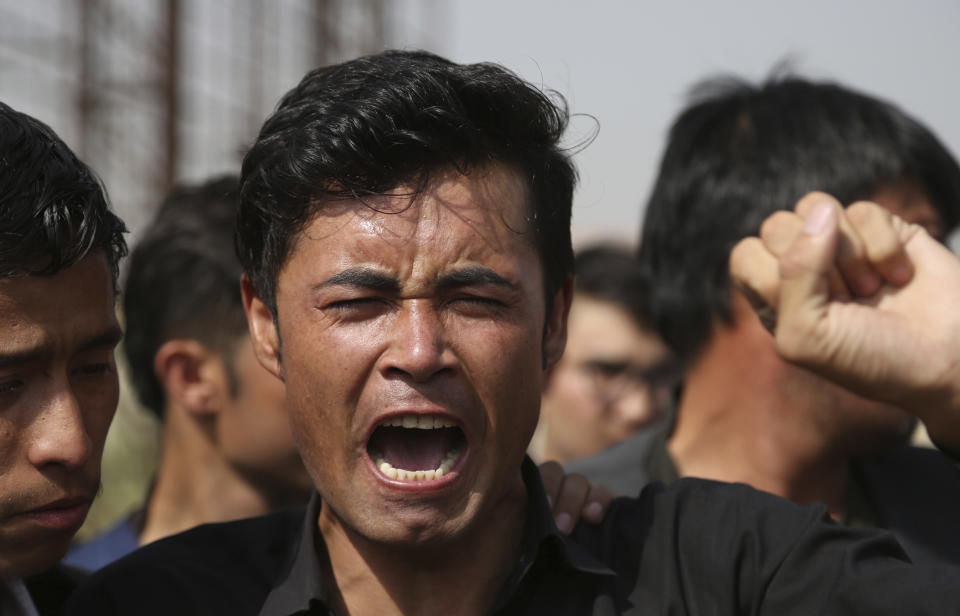 Relatives mourn a victim in western Kabul, Afghanistan, Thursday, Aug. 16, 2018, after Wednesday's deadly suicide bombing that targeted a training class in a private building in the Shiite neighborhood of Dasht-i Barcha. The Afghan authorities have revised the death toll from the previous day's horrific suicide bombing in a Shiite area of Kabul to 34 killed. (AP Photo/Rahmat Gul)