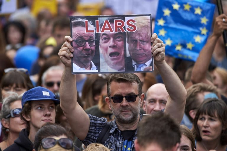 A woman holds up a placard depicting Michael Gove, Nigel Farage and Boris Johnson as liars as thousands of protesters take part in a march for Europe, through the centre of London on July 2, 2016, to protest against Britain's vote to leave the EU