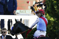 John Velazquez riding Medina Spirit throws a rose after his victory in the 147th running of the Kentucky Derby at Churchill Downs, Saturday, May 1, 2021, in Louisville, Ky. (AP Photo/Jeff Roberson)