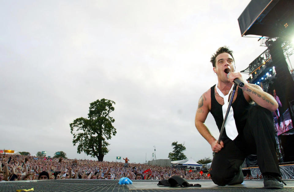 HERTFORDSHIRE, ENGLAND - AUGUST 1:  Singer Robbie Williams performs at Knebworth Park August 1, 2003 in Hertfordshire, England.  (Photo by Jon Furniss/Getty Images)