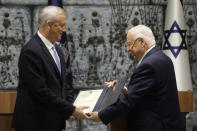 Israeli President Reuven Rivlin, right, hands a mandate to form new government to Blue and White Party leader Benny Gantz in Jerusalem, Wednesday, Oct. 23, 2019. (AP Photo/Sebastian Scheiner)