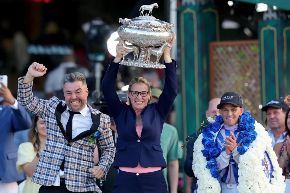 Arcangelo trainer Jena Antonucci, center, hoists the trophy alongside owner Jon Ebbert, left, and jockey Javier Castellano after their horse prevailed in the Belmont Stakes on Saturday.