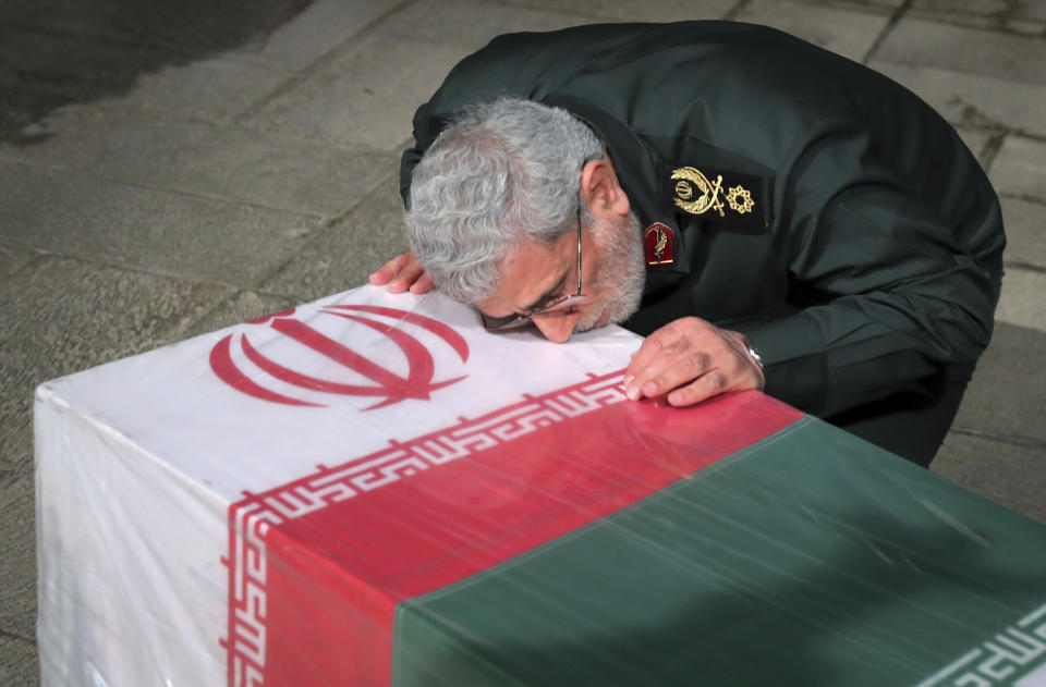 In this photo released by an official website of the office of the Iranian supreme leader, head of Iran's expeditionary Quds Force, Gen. Esmail Ghaani, places his face on the flag-draped coffin of Seyed Razi Mousavi, a high ranking Iranian general of the paramilitary Revolutionary Guard, who was killed in an alleged Israeli airstrike in Syria on Monday, at supreme leader's office compound in Tehran, Iran, Thursday, Dec. 28, 2023. (Office of the Iranian Supreme Leader via AP)