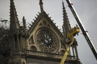 Technicians work in a crane next to the Notre Dame cathedral in Paris, Monday, April 22, 2019. n the wake of the fire last week that gutted Notre Dame, questions are being raised about the state of thousands of other cathedrals, palaces and village spires that have turned France — as well as Italy, Britain and Spain — into open air museums of Western civilization. (AP Photo/Francisco Seco)