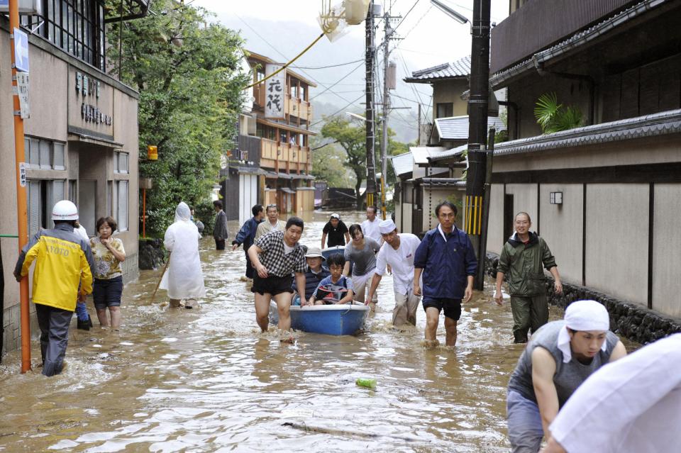 Guests at a Japanese inn are rescued by boat along a flooded road after tropical storm Man-yi made landfall in Kyoto