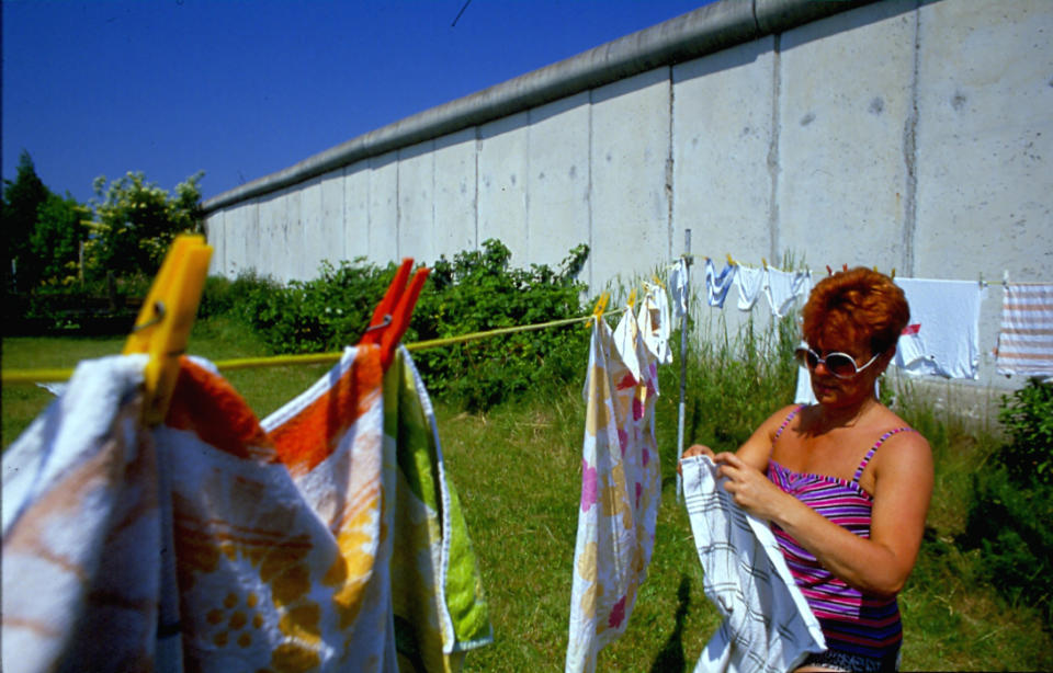 <p>Una mujer tiende varias prendas de ropa. Tal y como se aprecia en la foto, el muro sirve como frontera de su vivienda. (Photo by Thierlein/ullstein bild via Getty Images)</p> 