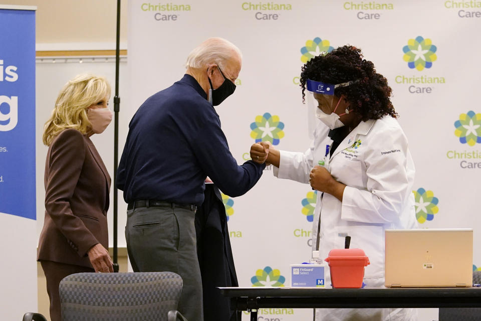 President-elect Joe Biden fist bumps with nurse practitioner Tabe Mase after receiving his first dose of the coronavirus vaccine at ChristianaCare Christiana Hospital in Newark, Del., Monday, Dec. 21, 2020, as Jill Biden looks on. (AP Photo/Carolyn Kaster)