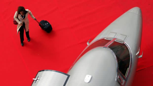 A woman walks next to an aircraft at LABACE fair at Congonhas Airport in Sao Paulo