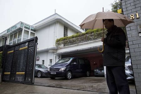 A security stands guard outside the house of Hong Kong media tycoon Jimmy Lai in Hong Kong January 12, 2015. REUTERS/Tyrone Siu