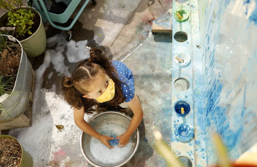 LOS ANGELES-AUGUST 27, 2020: A child wears a mask while painting at Voyages Preschool in Los Angeles on Thursday, August 27, 2020. (Christina House / Los Angeles Times)