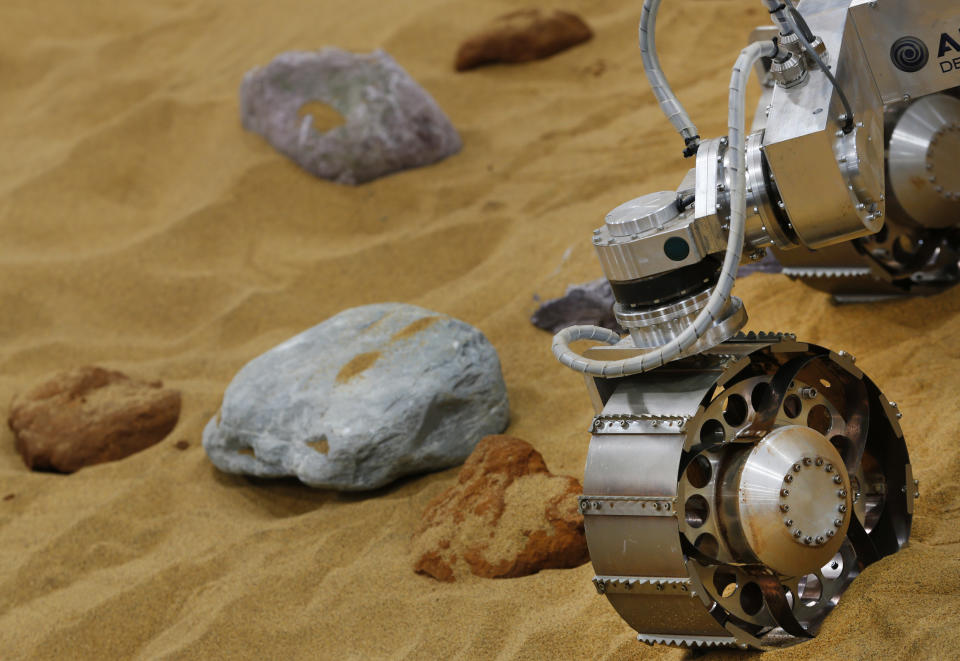 A robotic vehicle on the 'Mars Yard Test Area', a testing ground for the robotic vehicles of the European Space Agency’s ExoMars program scheduled for 2018, moves in Stevenage, England, Thursday, March 27, 2014. It looks like a giant sandbox - except the sand has a reddish tint and the “toys” on display are very expensive prototypes designed to withstand the rigors of landing on Mars. The scientists here work on the development of the autonomous navigation capabilities of the vehicle, so by being in communication with controllers on earth twice a day, will be able to use the transmitted information to navigate to new destinations on Mars. But it won’t be fast - maximum range is about 70 meters (210 feet) per day. (AP Photo/Lefteris Pitarakis)