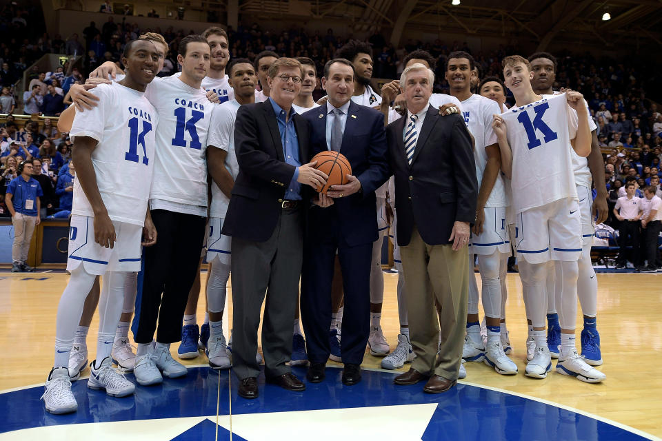 Duke coach Mike Krzyzewski (C) poses for photos with school president Vincent Price (L), athletic director Kevin White (R) and his team following Krzyzewski's 1,000th victory on November 11, 2017. (Lance King/Getty)