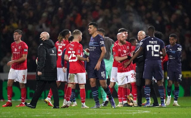 Swindon and Manchester City players shake hands after the final whistle