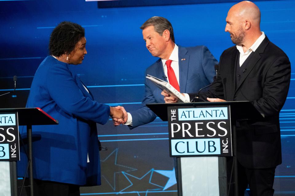 Democratic challenger Stacey Abrams, from left, shakes hands with Georgia Republican Gov. Brian Kemp as Libertarian challenger Shane Hazel stands at right following the Atlanta Press Club Loudermilk-Young Debate Series in Atlanta, Monday, Oct. 17, 2022.