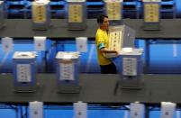 An election official runs with an unopened ballot box for Japan's upper house election at a counting centre in Tokyo