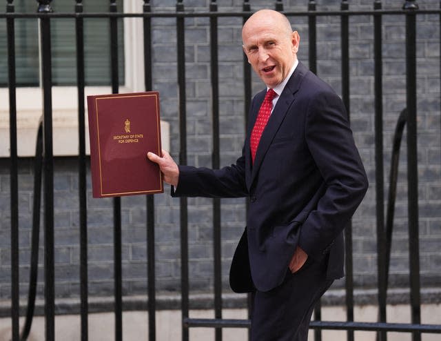 Defence Secretary John Healey holds up a folder: 