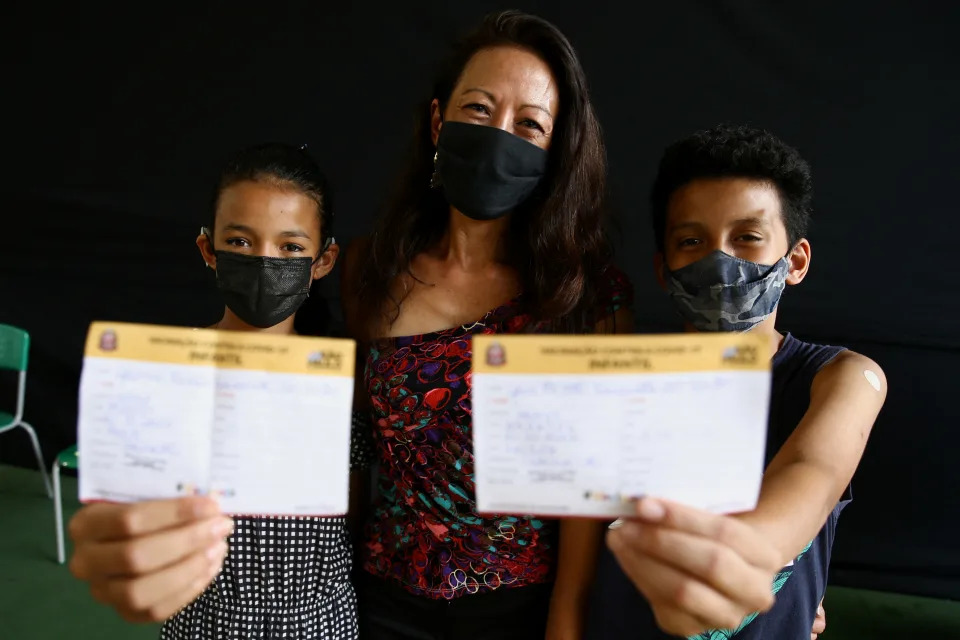 Angela Kawamoto dos Santos and her children Yasmin and Yuri pose for a photo after they received a dose of Sinovac Biotech&#39;s Coronavac vaccine against the coronavirus disease (COVID-19), as the National Health Surveillance Agency (ANVISA) approved its use for children, in Sao Paulo, Brazil, January 20, 2022. REUTERS/Carla Carniel