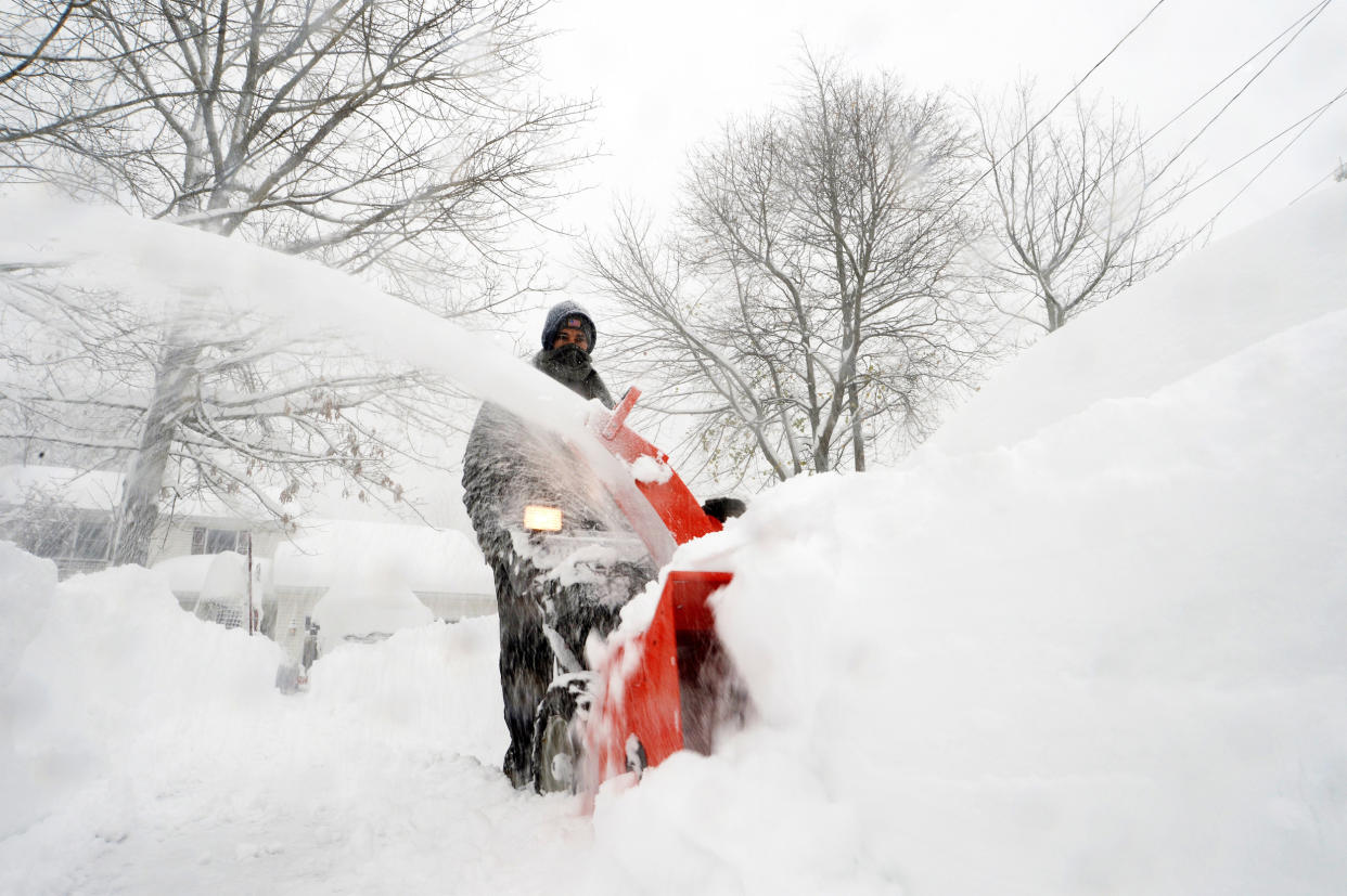 A man uses a snowblower to clear snow in Hamburg, N.Y. (John Normile / Getty Images)