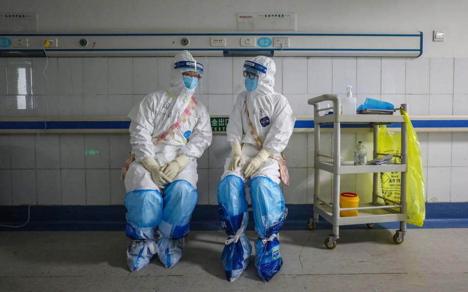 This photo taken on February 16, 2020 shows medical staff members talking at the Wuhan Red Cross Hospital in Wuhan in China's central Hubei province