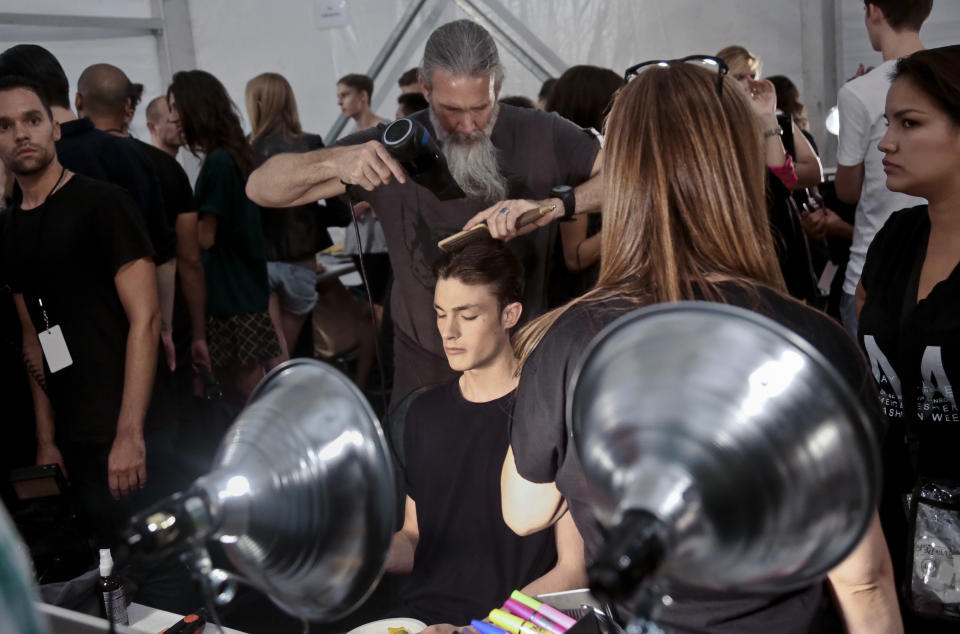 Hairstylist Jeff Wacker, standing center, styles Duncan Proctor, 19, a model from Brighton, England, for the Richard Chai Spring Summer 2014 collection on Thursday, Sept. 5, 2013 during Fashion Week in New York. (AP Photo/Bebeto Matthews)